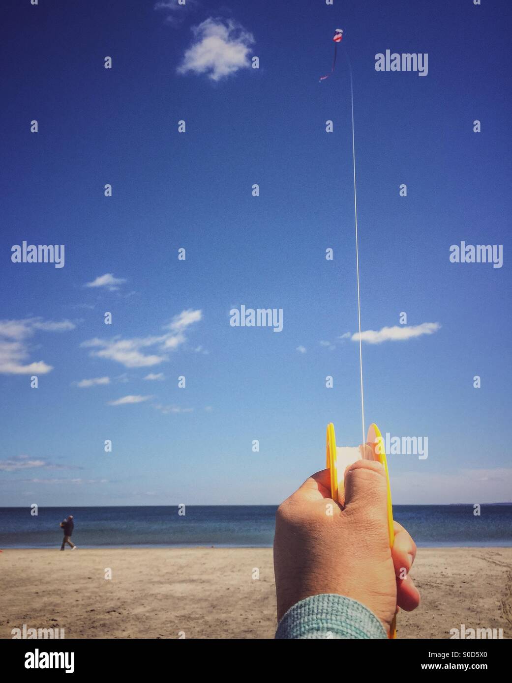 Hand holding a kite string on the beach Stock Photo - Alamy