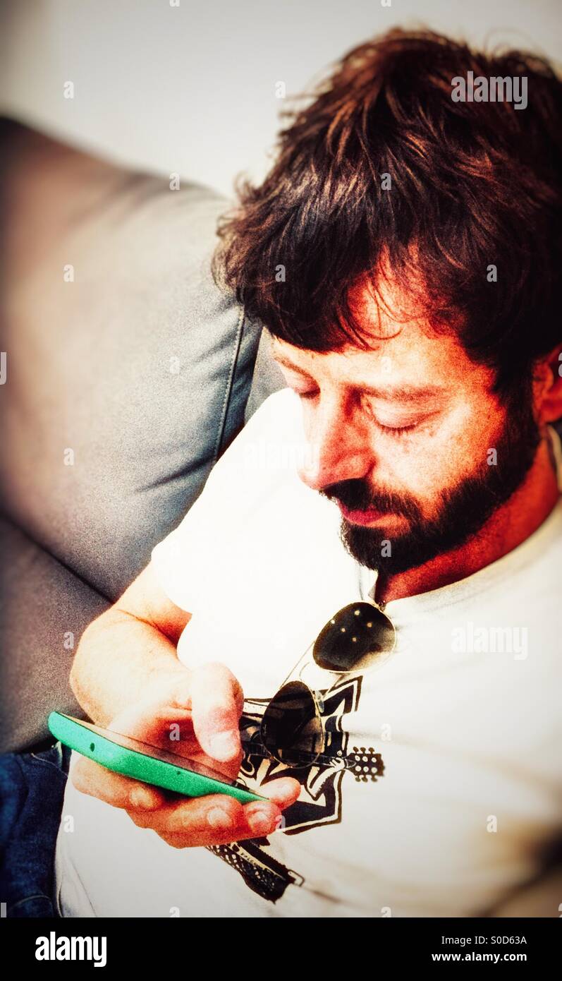 Man messaging through smartpgone - Smartphone Captured Stock Image