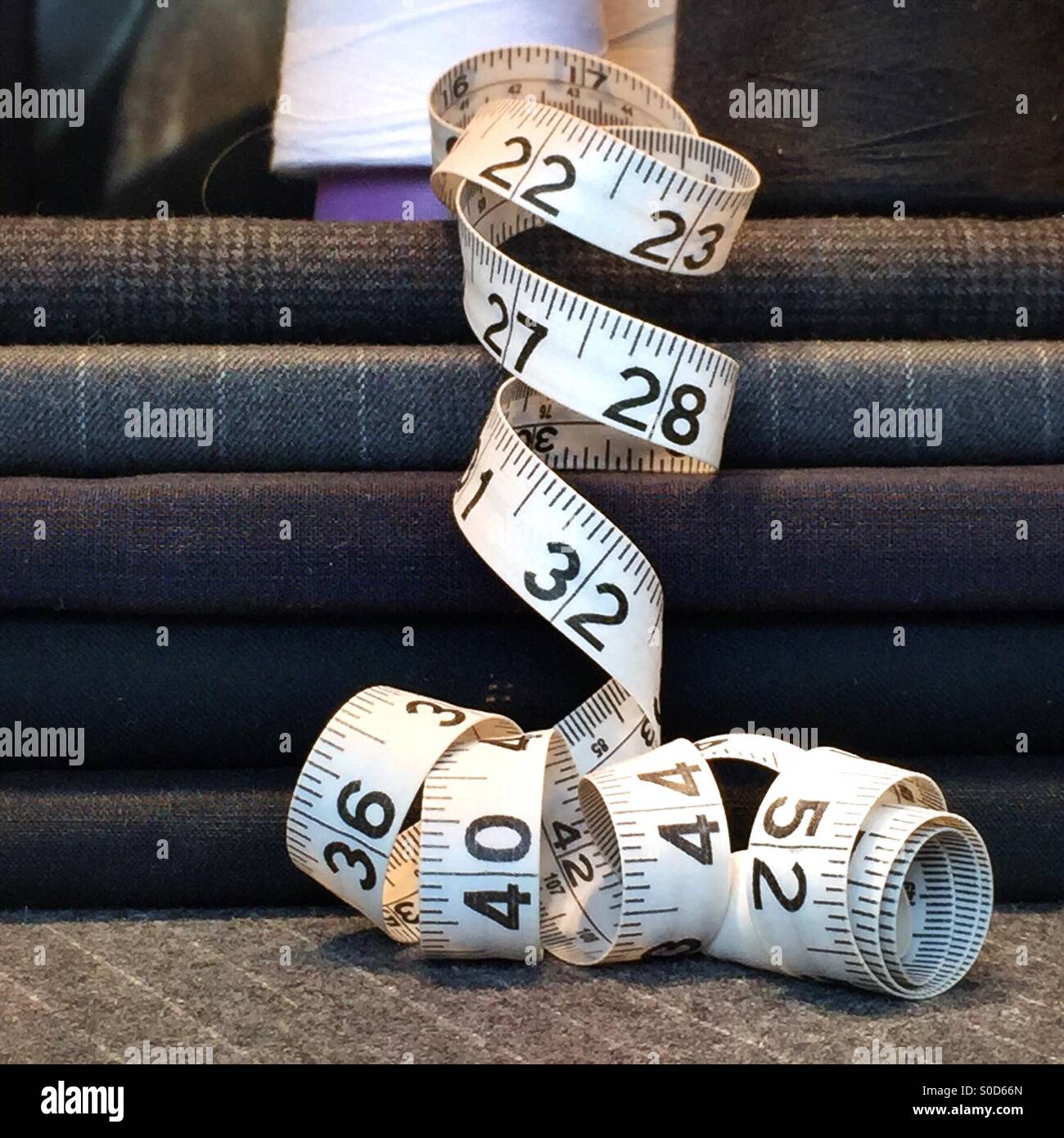 A tape measure lies near material for making men's suits. - Smartphone Captured Stock Image