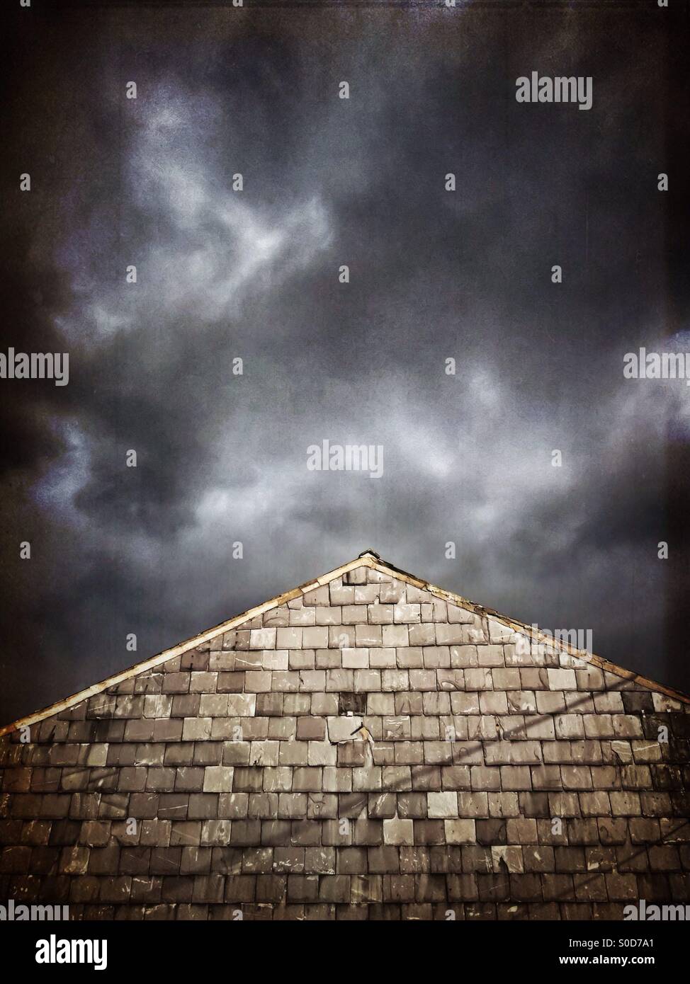 Slate covered wall against slate coloured sky - Smartphone Captured Stock Image