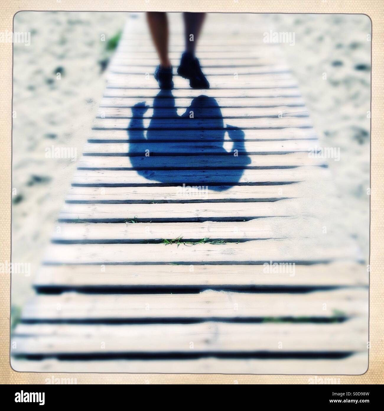 shadow of man walking on a boardwalk - Smartphone Captured Stock Image