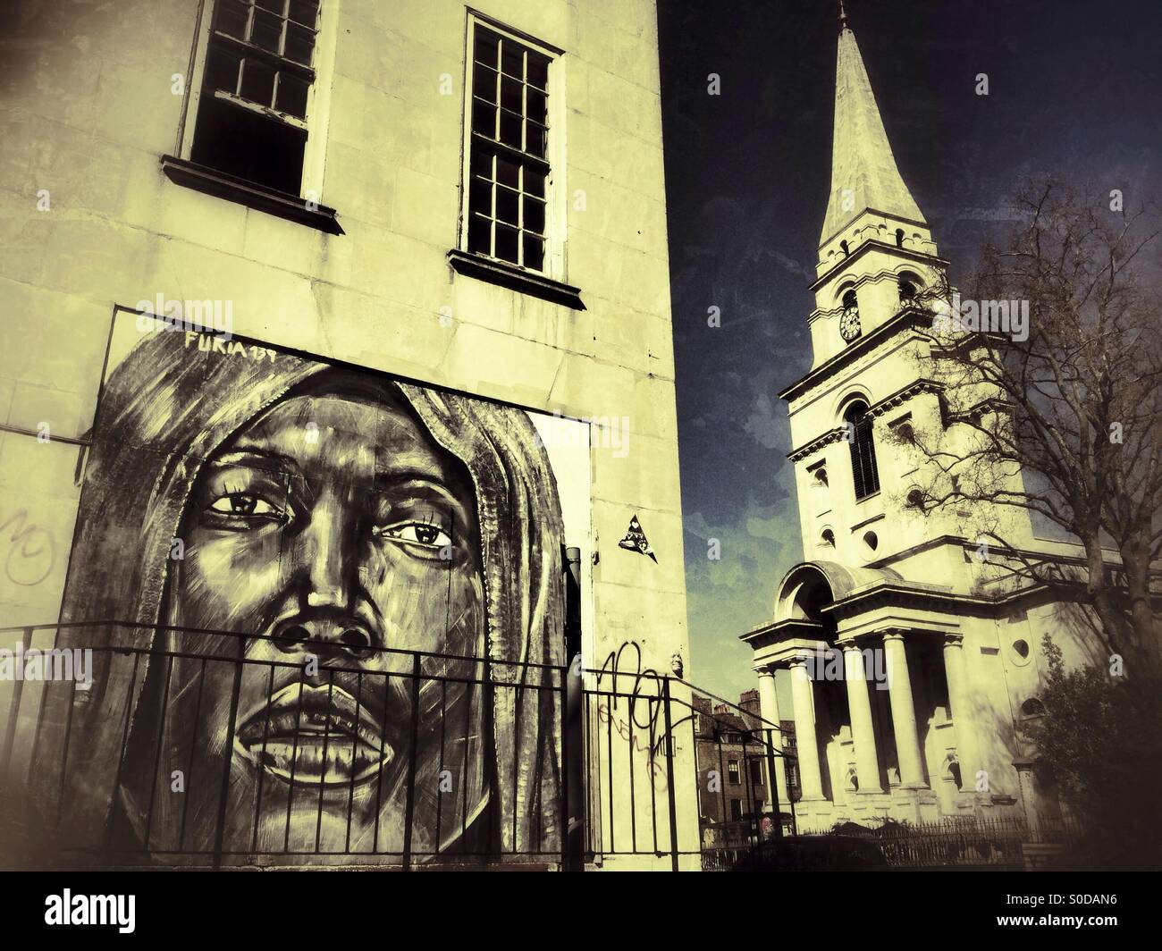Street art by Portuguese artist Furia ACK with Christ Church Spitalfields in the background. Commercial Rd, Spitalfields, London, UK. - Smartphone Captured Stock Image