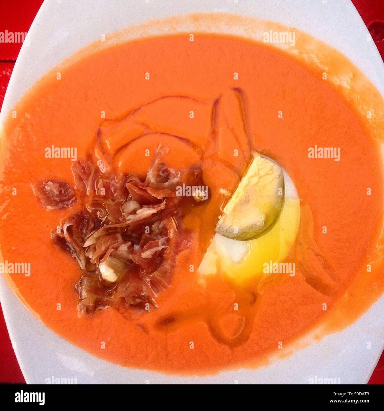 A 'salmorejo', tomato soup with a boiled egg an Iberiam ham, in Taberna Jovenes Flamencos restaurant in Arcos de la Frontera, Sierra de Cadiz, Andalusia, Spain - Smartphone Captured Stock Image
