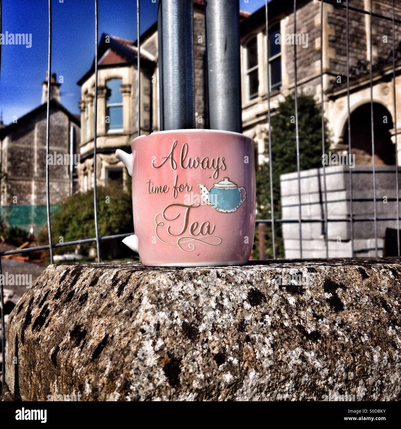 'Always time for Tea': a broken mug abandoned on a wall on a city street. - Smartphone Captured Stock Image