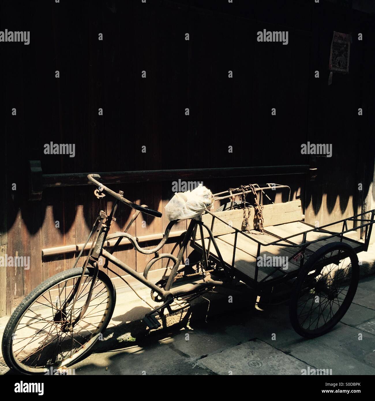 Tricycle against doors Stock Photo Alamy