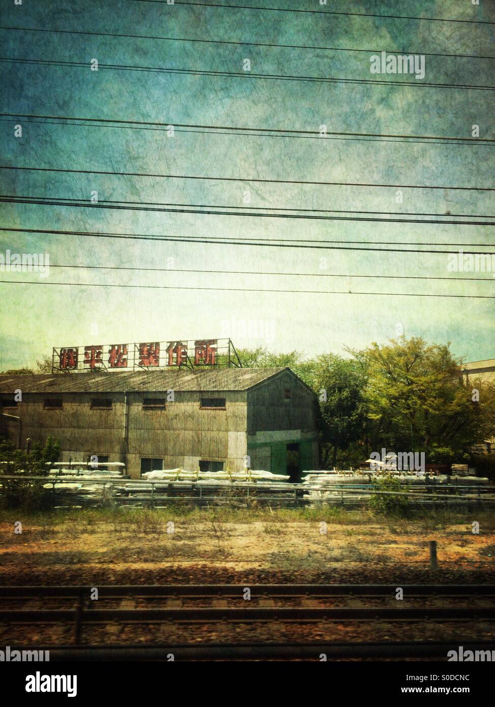 Hiramatsu Seisakujo, manufacturer of machinery parts in Nagoya, Japan. View from Shinkansen or bullet train window. Vintage paper texture overlay. Stock Photo
