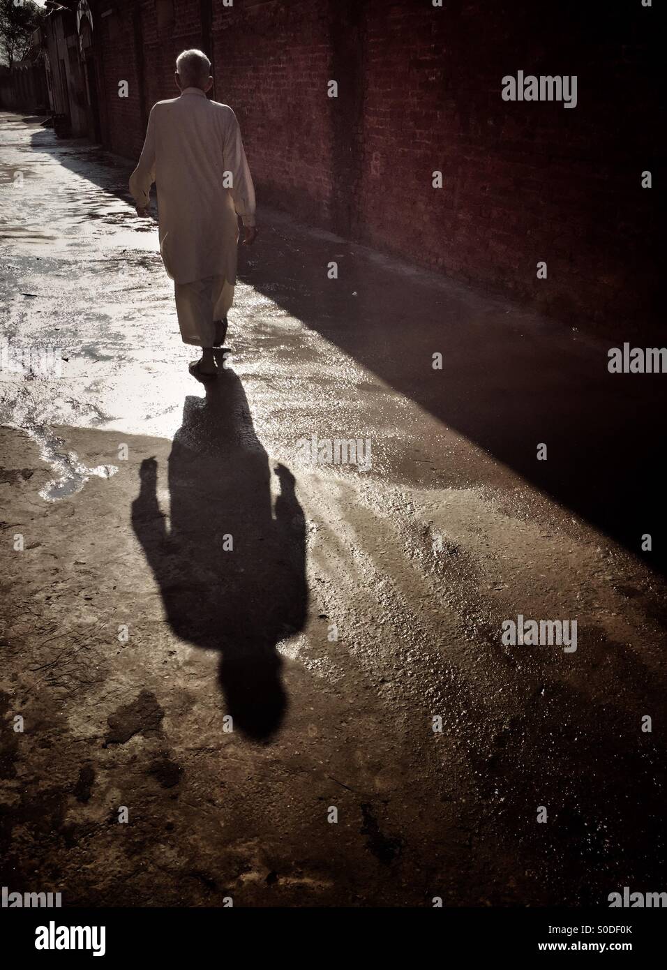 Man walking in the alley Kharian village Pakistan - Smartphone Captured Stock Image