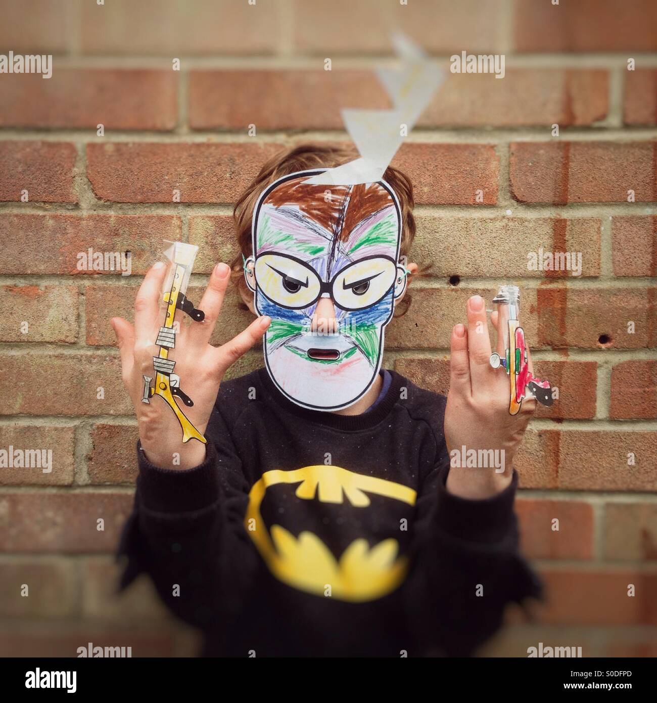 Five year old boy playing wearing a superhero mask. - Smartphone Captured Stock Image