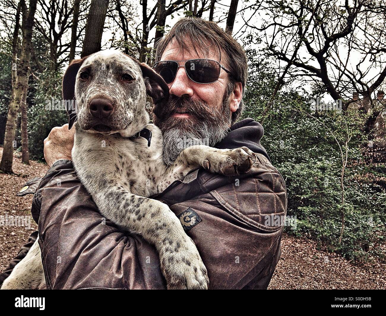 Man holding puppy on a walk in the woods Stock Photo
