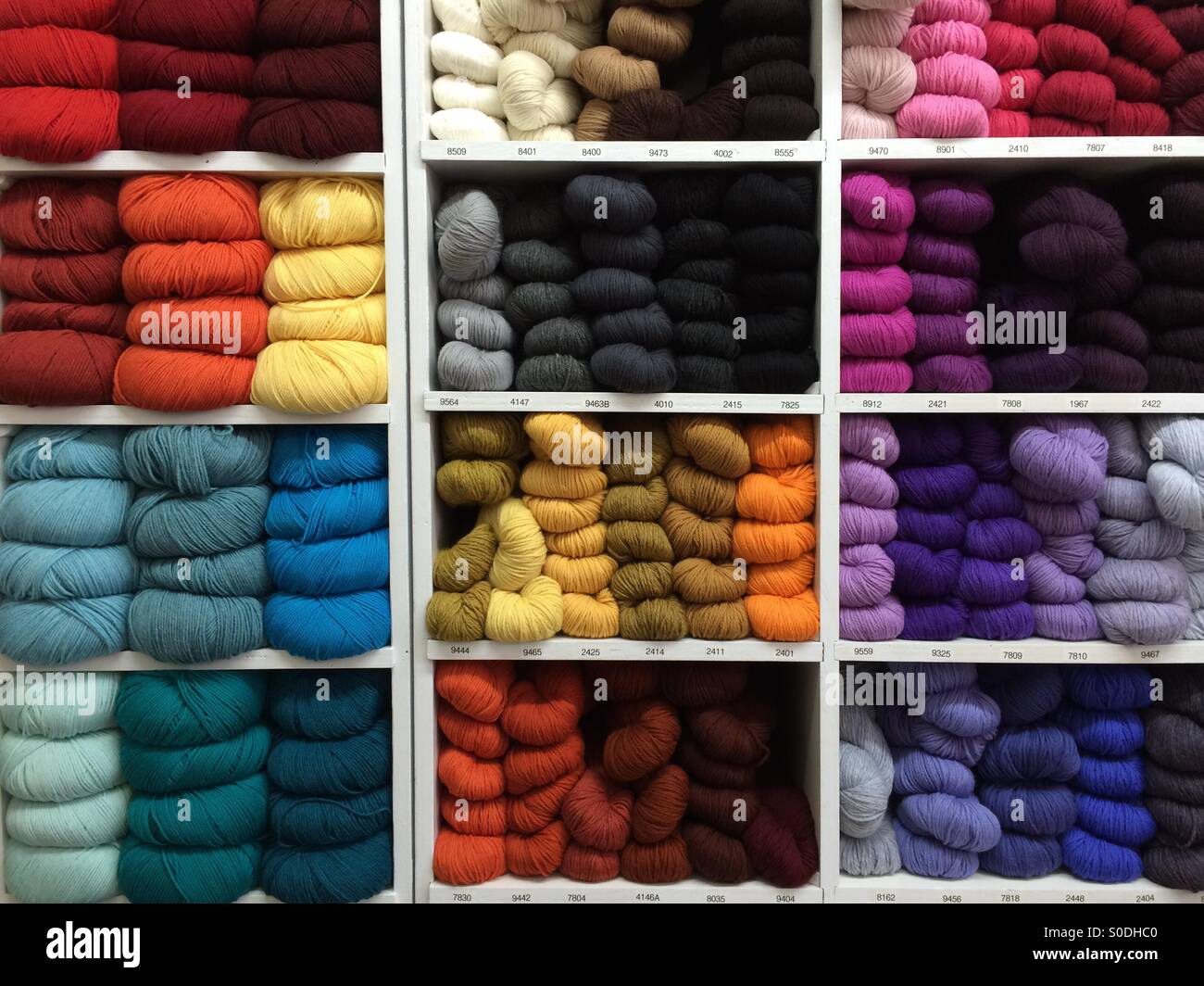 Many colours of yarn stacked in shelves Stock Photo Alamy