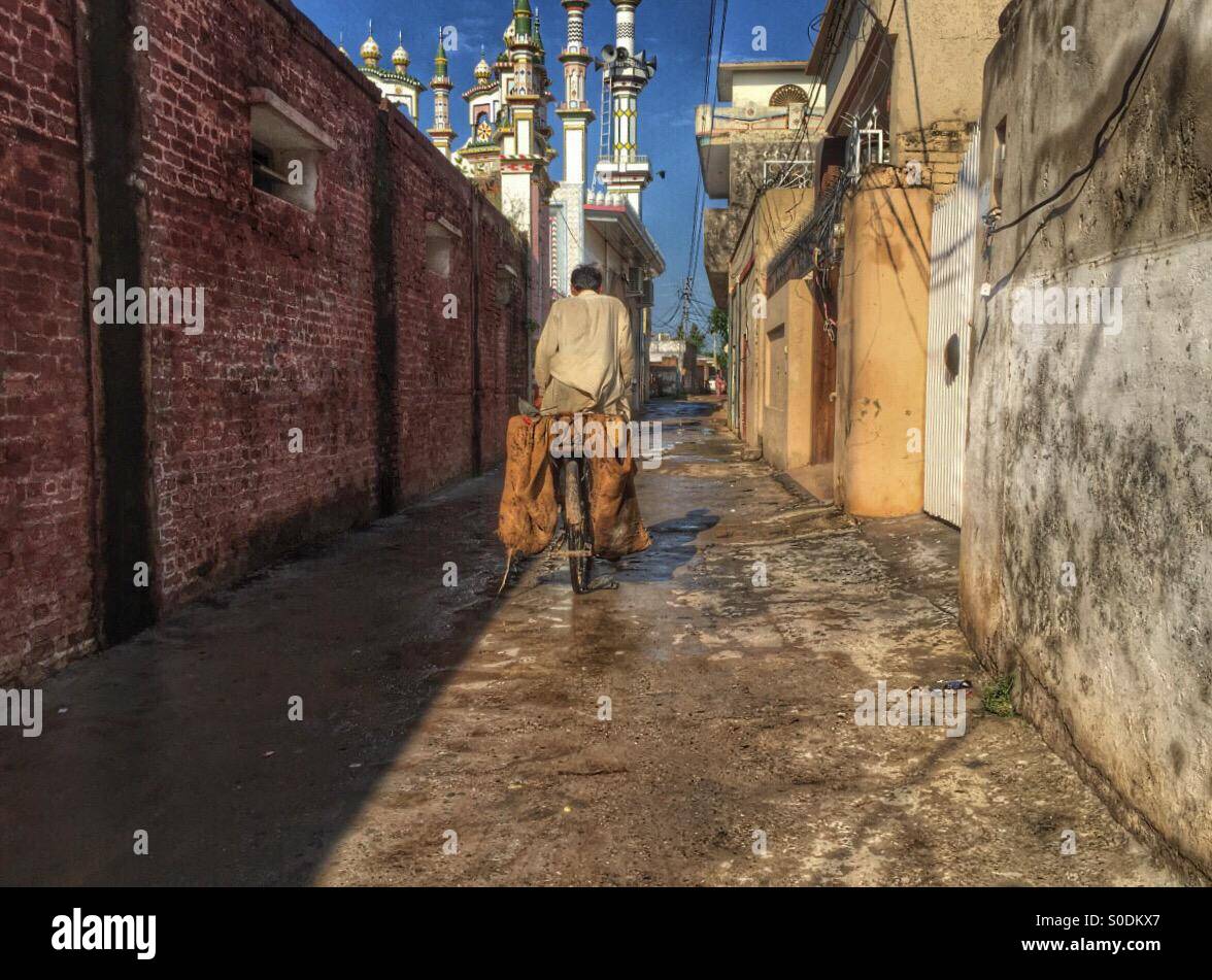 Man riding bike in Kharian village Pakistan - Smartphone Captured Stock Image