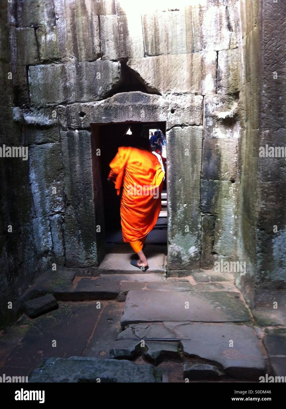 Buddhist monk in stone doorway Stock Photo
