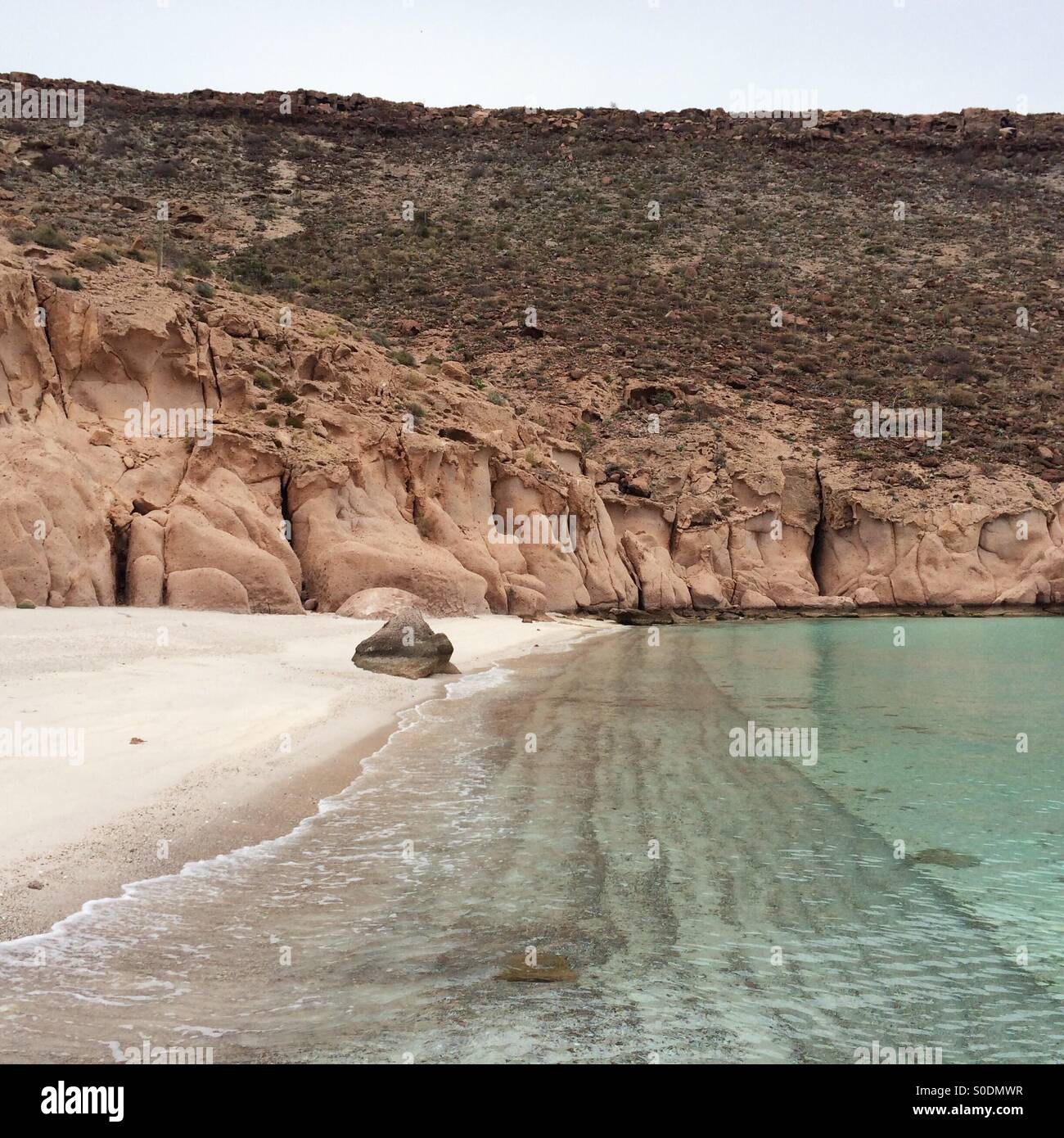 Baja California Sur empty clean beach with desert rocks on the back Stock Photo