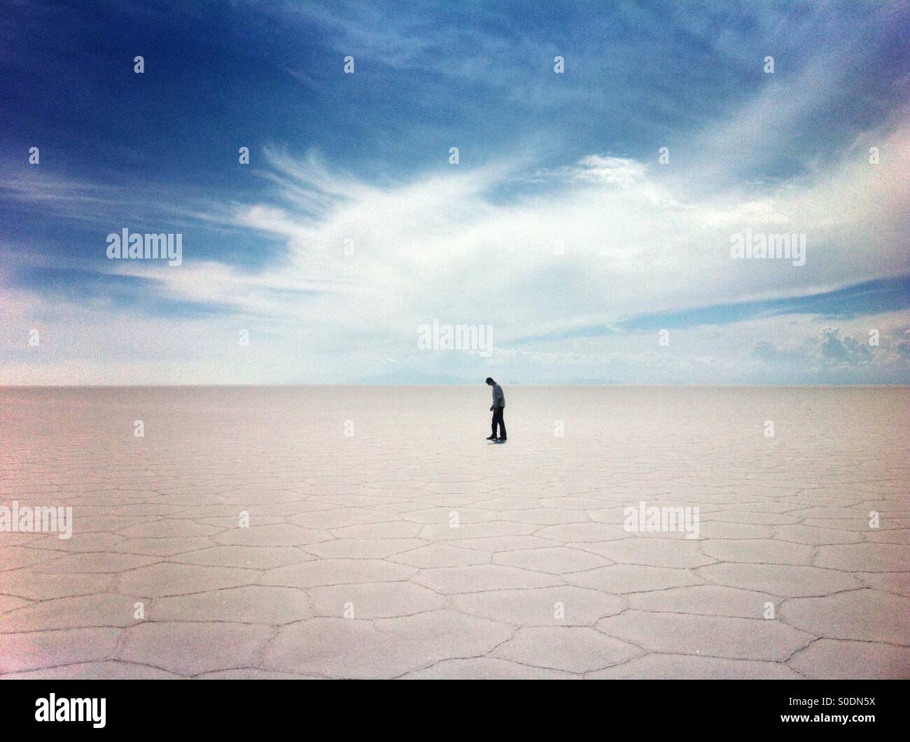 A tourist walks through the Salar de Uyuni in Bolivia - Smartphone Captured Stock Image