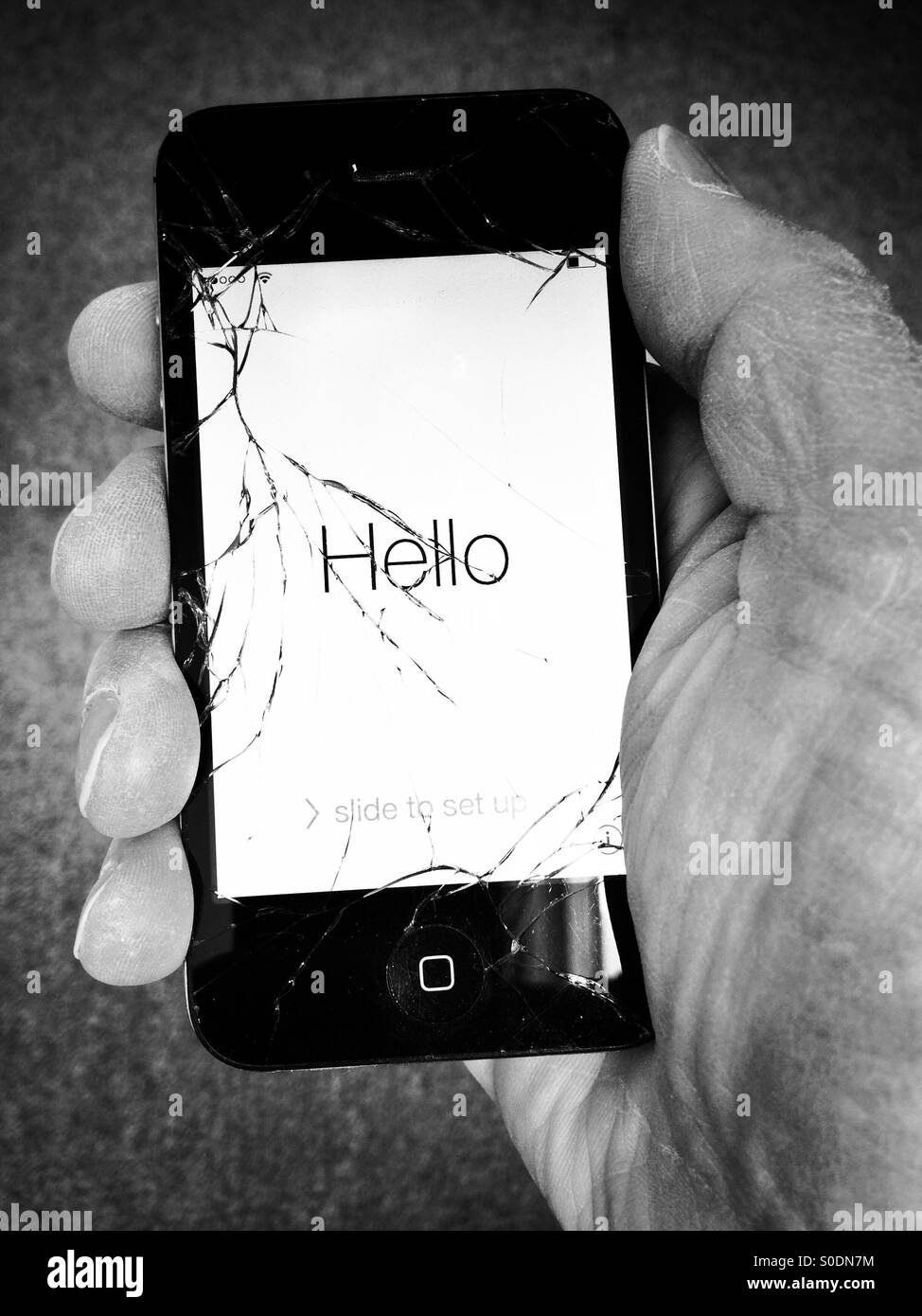 Hand holding iPhone 4S with broken screen Stock Photo