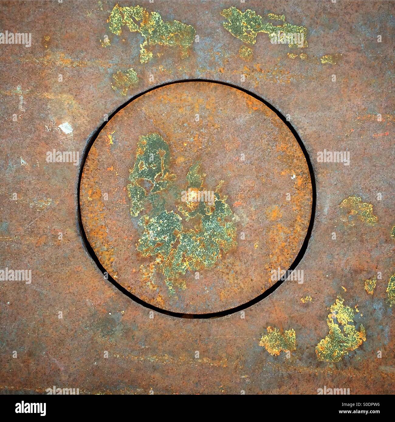 Drain hole in street with verdigris - Smartphone Captured Stock Image