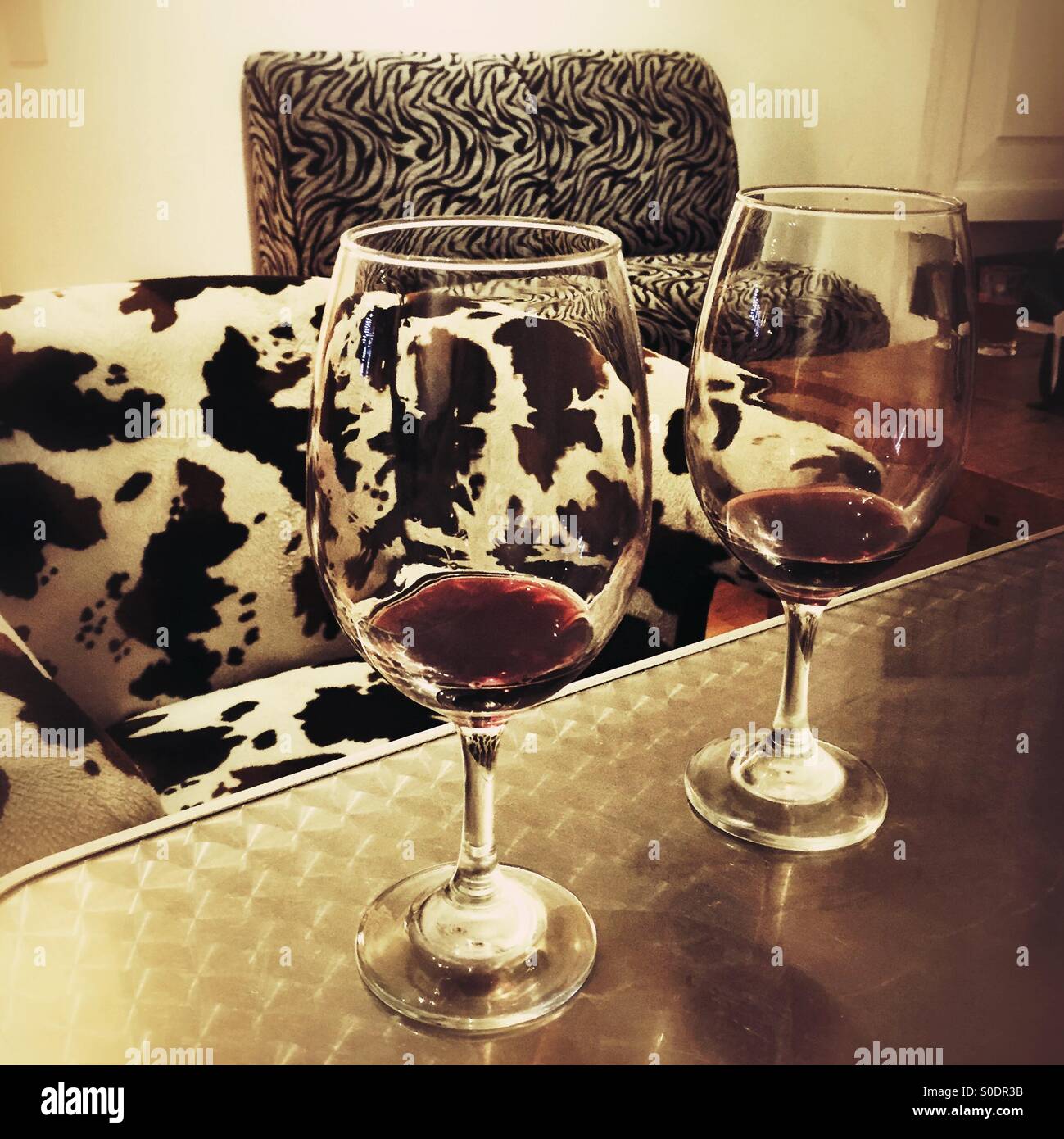 Two Almost Empty Wine Glasses On A Table In Front Of Animal Print Stock Photo Alamy