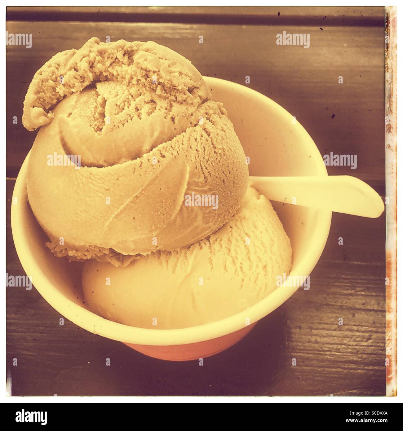 Small carton of ice cream with plastic spoon. - Smartphone Captured Stock Image