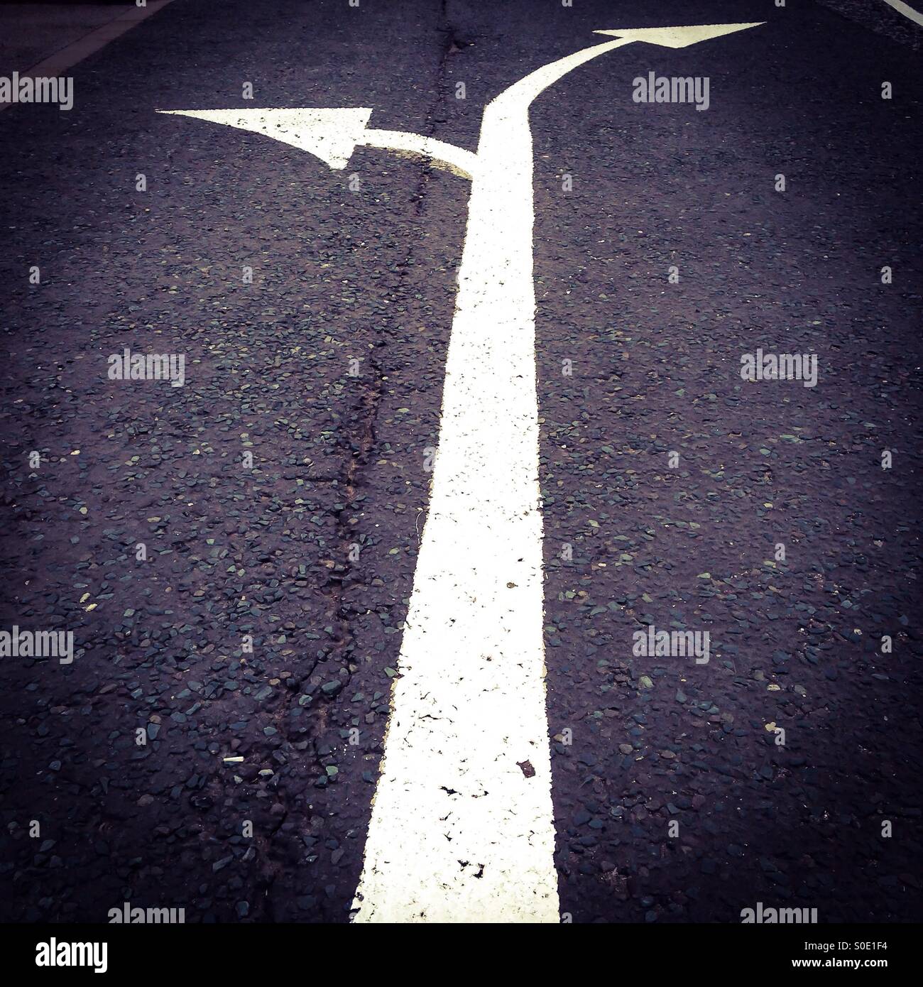 A double headed arrow painted on a road Stock Photo - Alamy