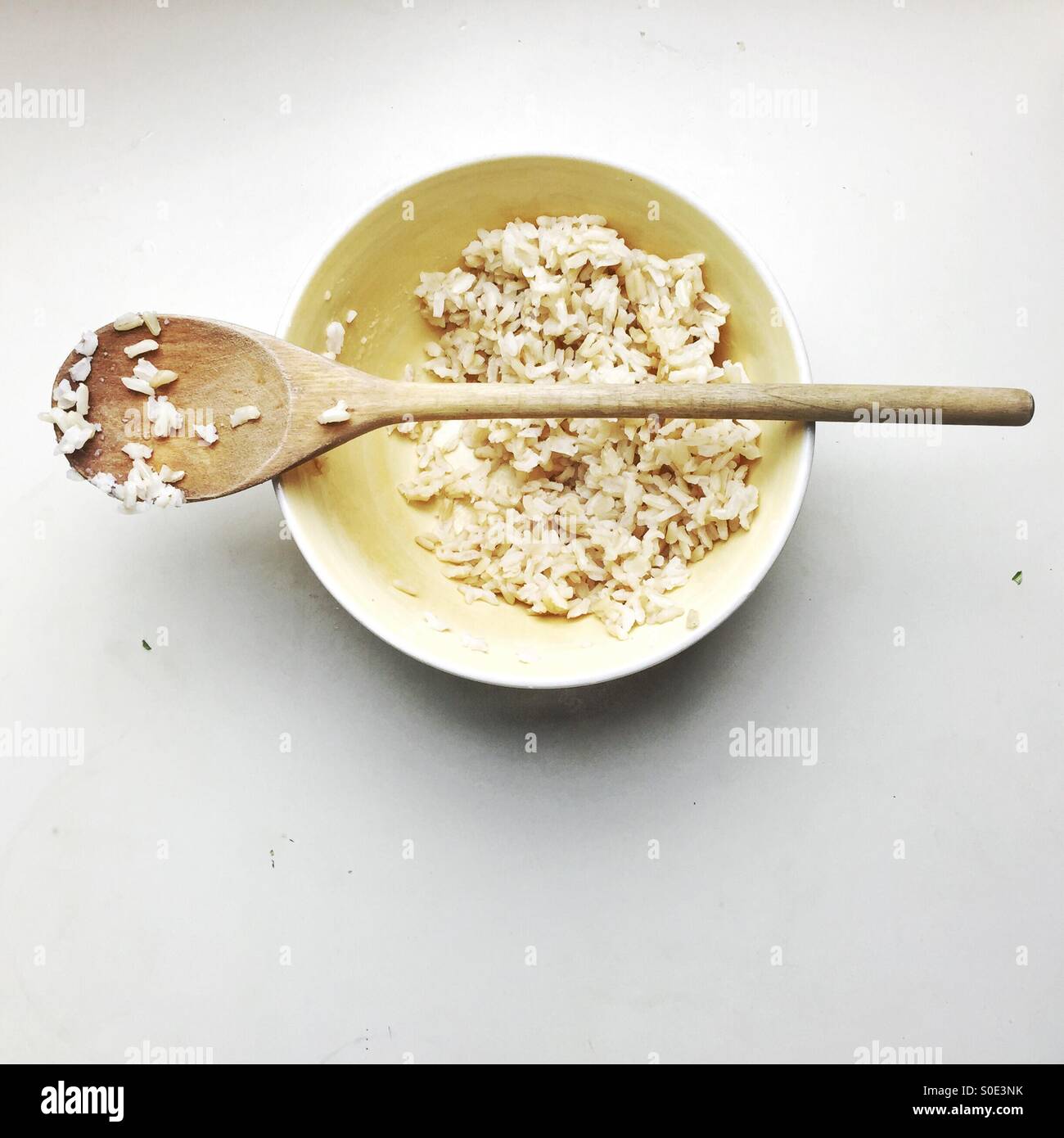 bowl of rice and wooden spoon Stock Photo