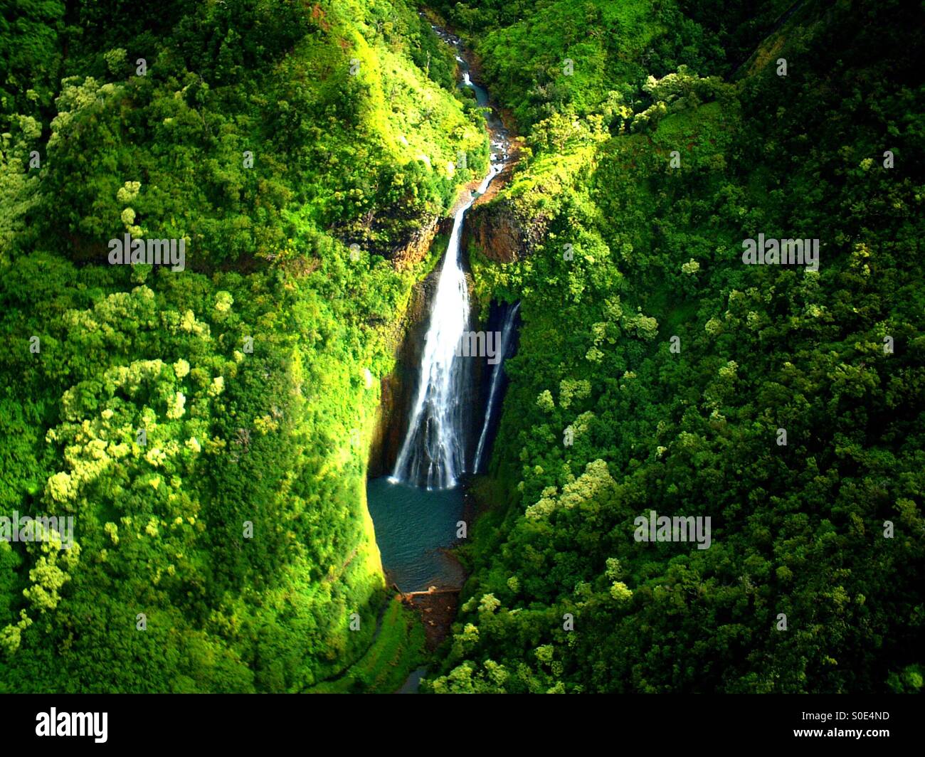 Helicopter view of 100+ foot waterfall, one of many in Kauai's lush Napali Coast jungles, and one of the wettest places on earth - Smartphone Captured Stock Image