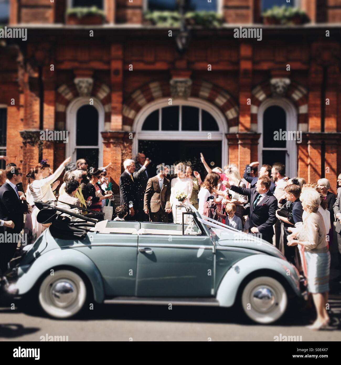Couple Just Married With Wedding Party And Vintage Vw Beetle