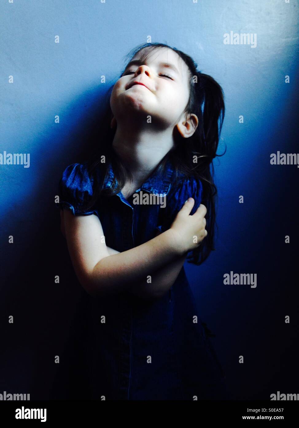 3-year old girl wearing denim dress Stock Photo