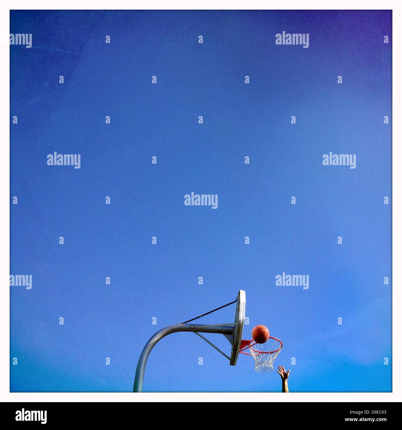 Basketball hoop and hand of a player Just scoring - Smartphone Captured Stock Image