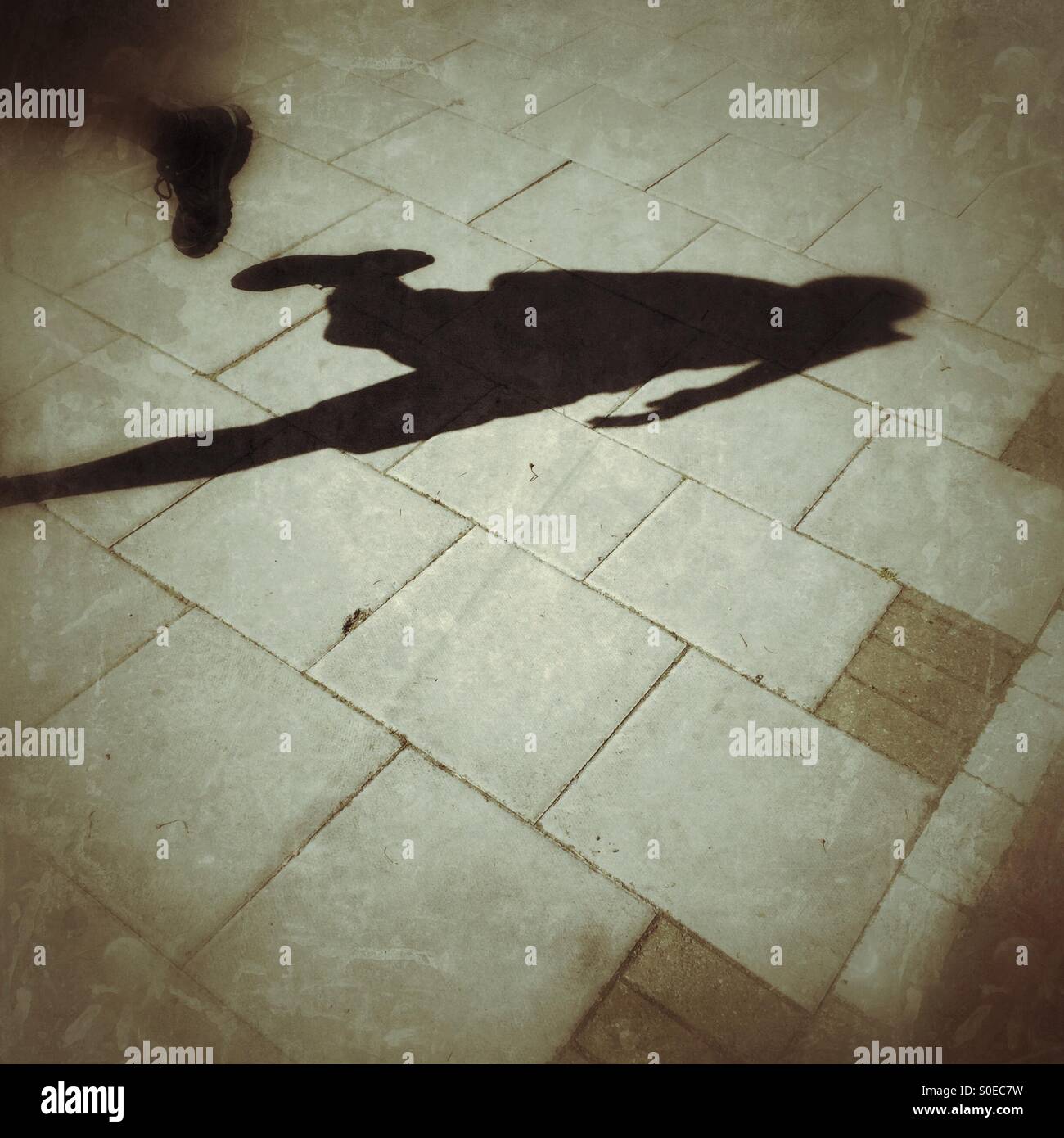 Shadow of someone running down the street. - Smartphone Captured Stock Image