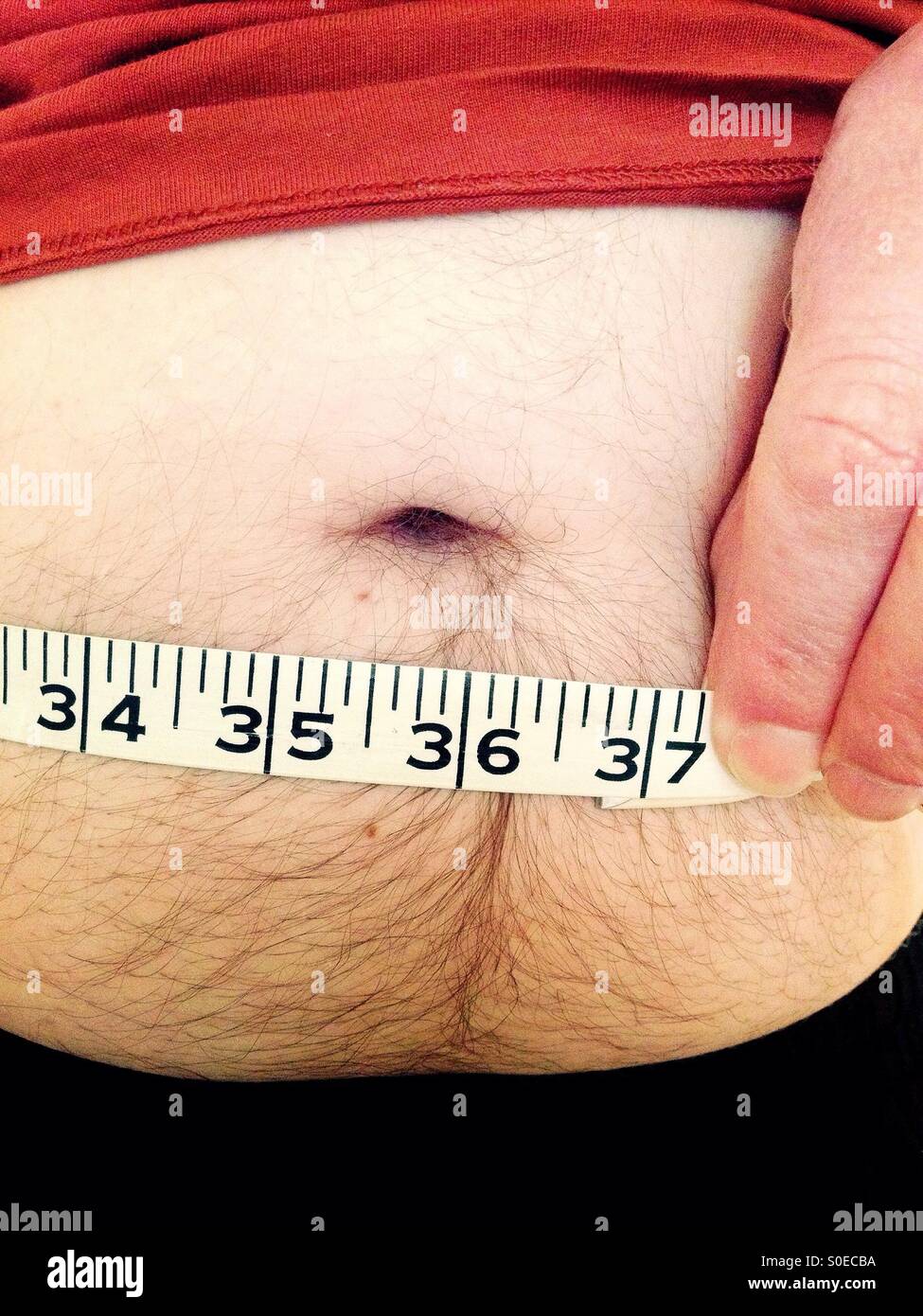 Man measuring his waistline Stock Photo