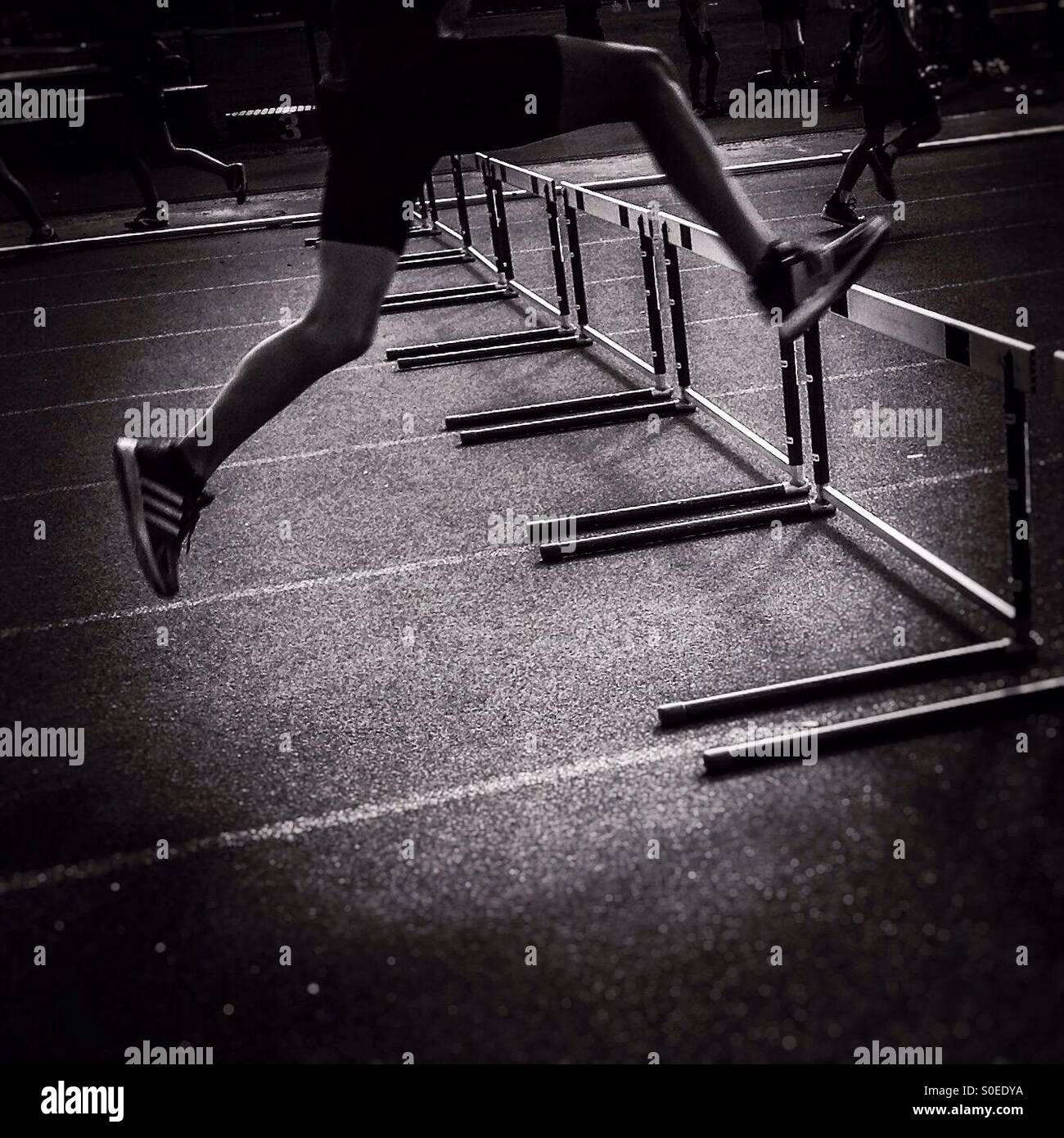 Athlete jumping hurdles Stock Photo