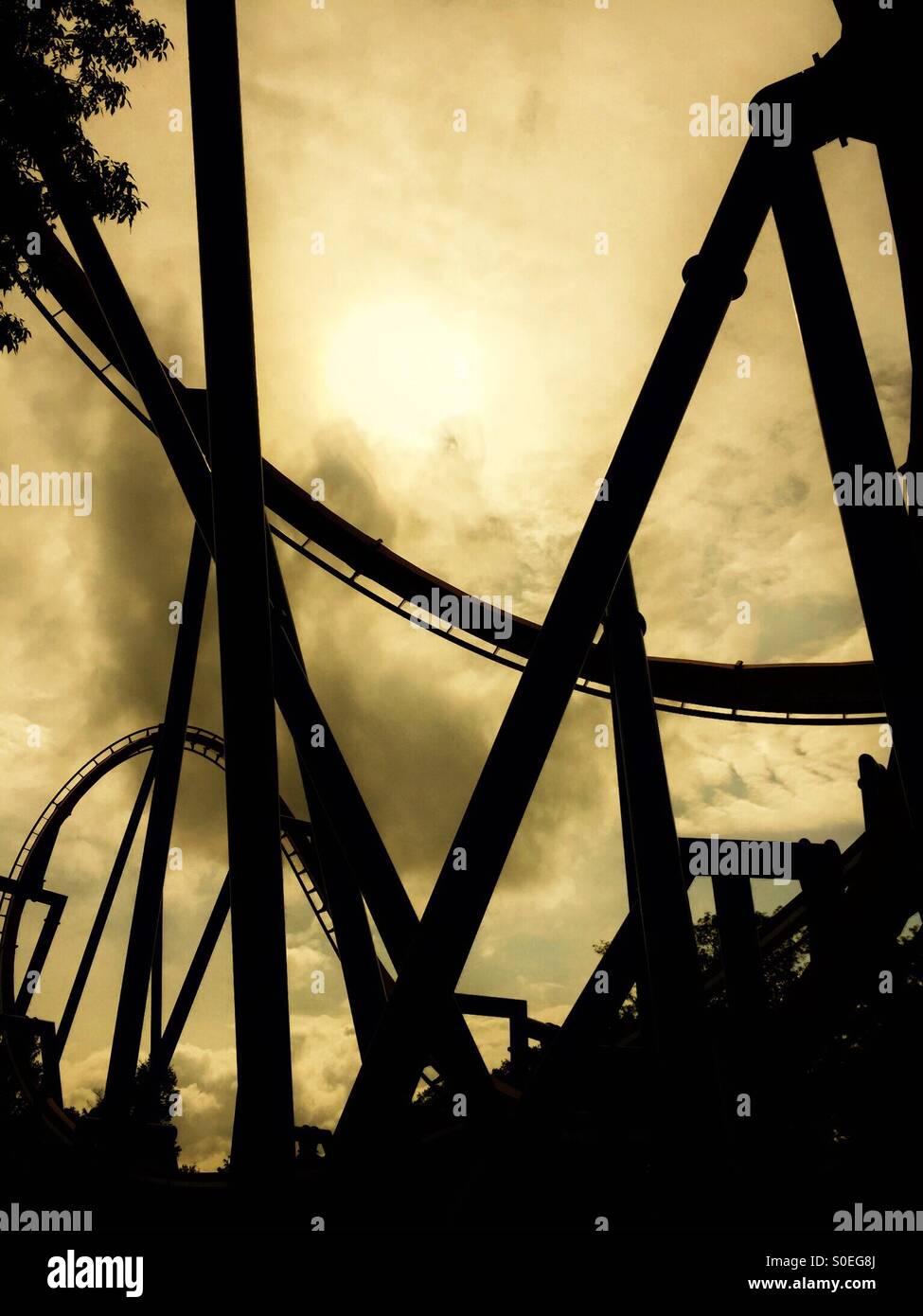 Silhouette of a roller coaster against a cloudy sky - Smartphone Captured Stock Image