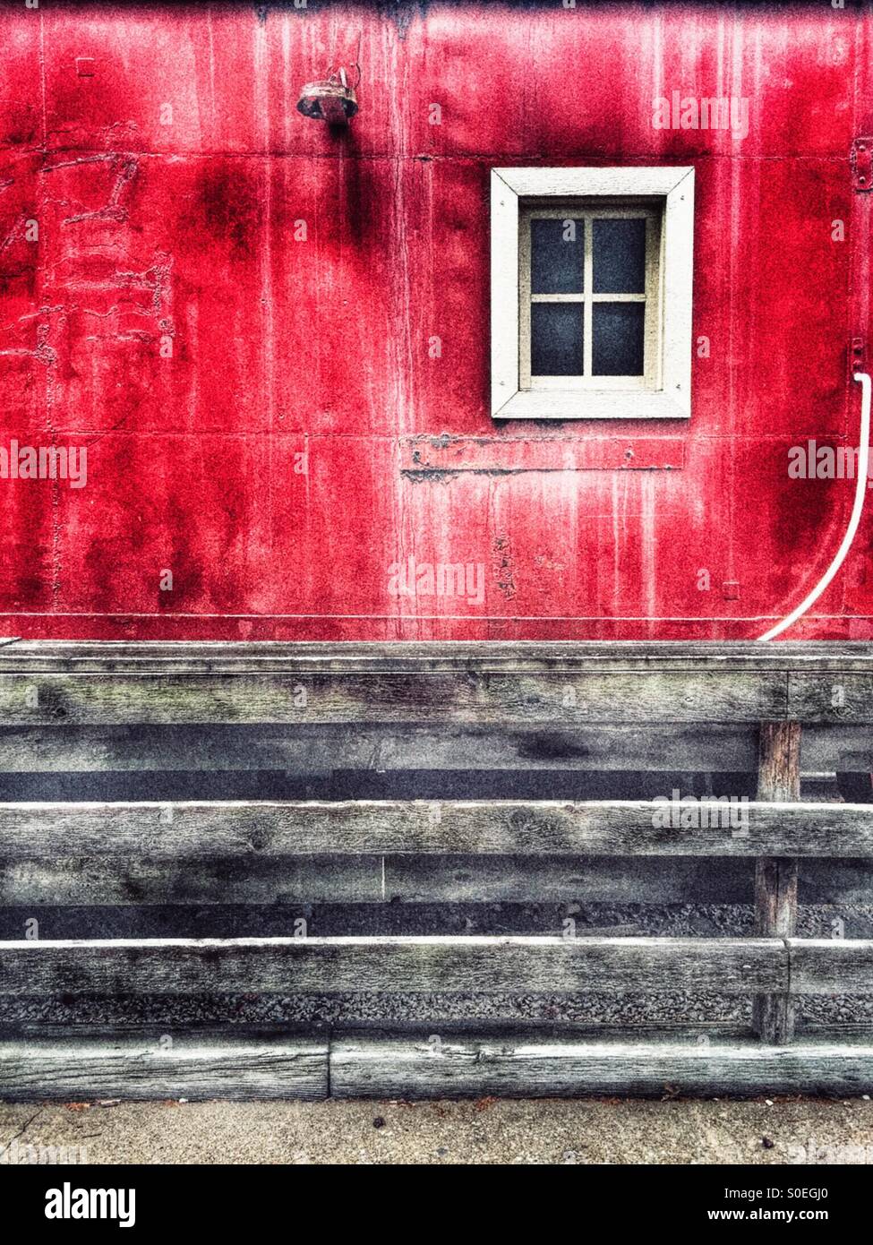 Square white window on red weathered caboose wall - Smartphone Captured Stock Image
