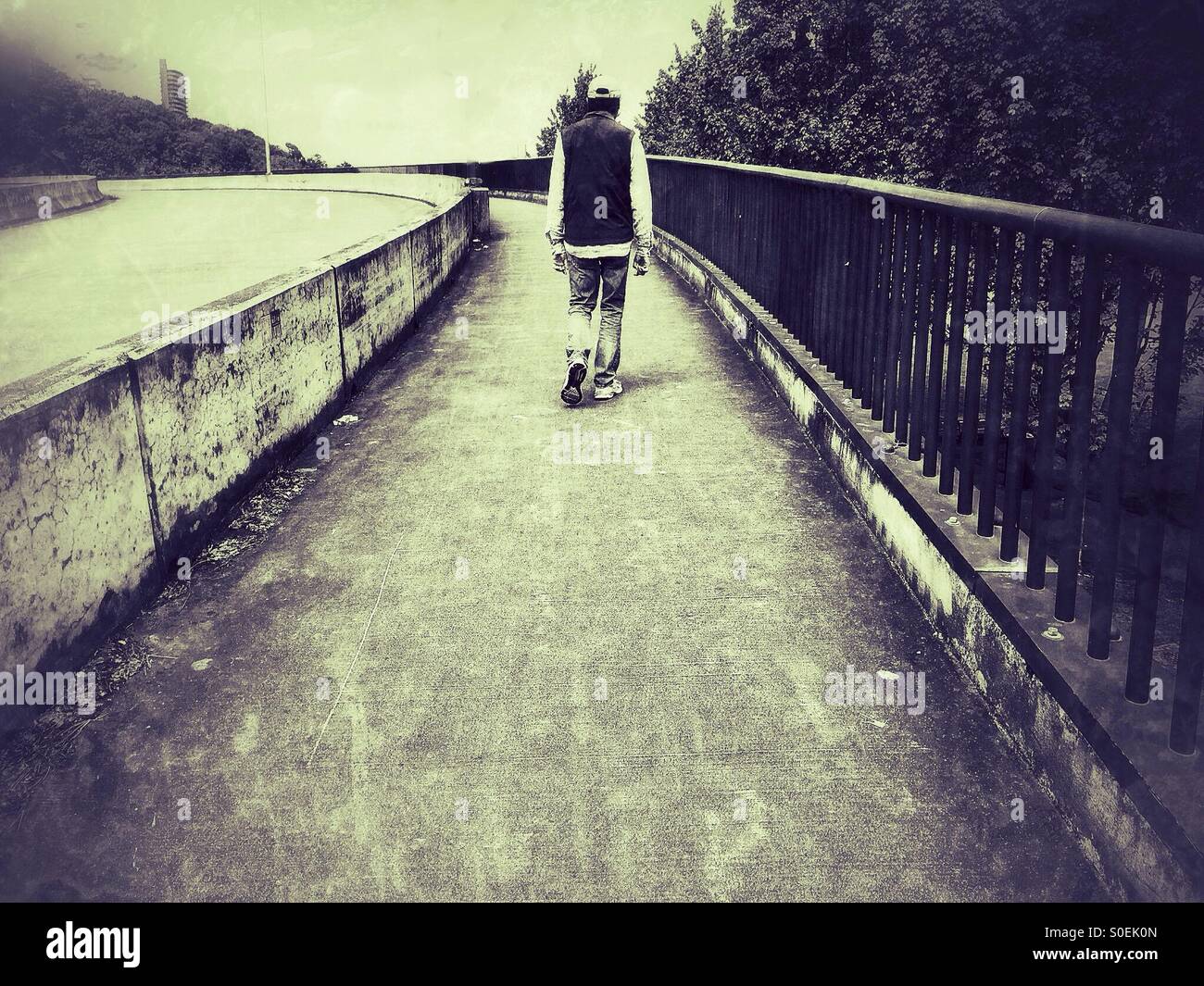 Man walks away on a bridge, grunge filter - Smartphone Captured Stock Image