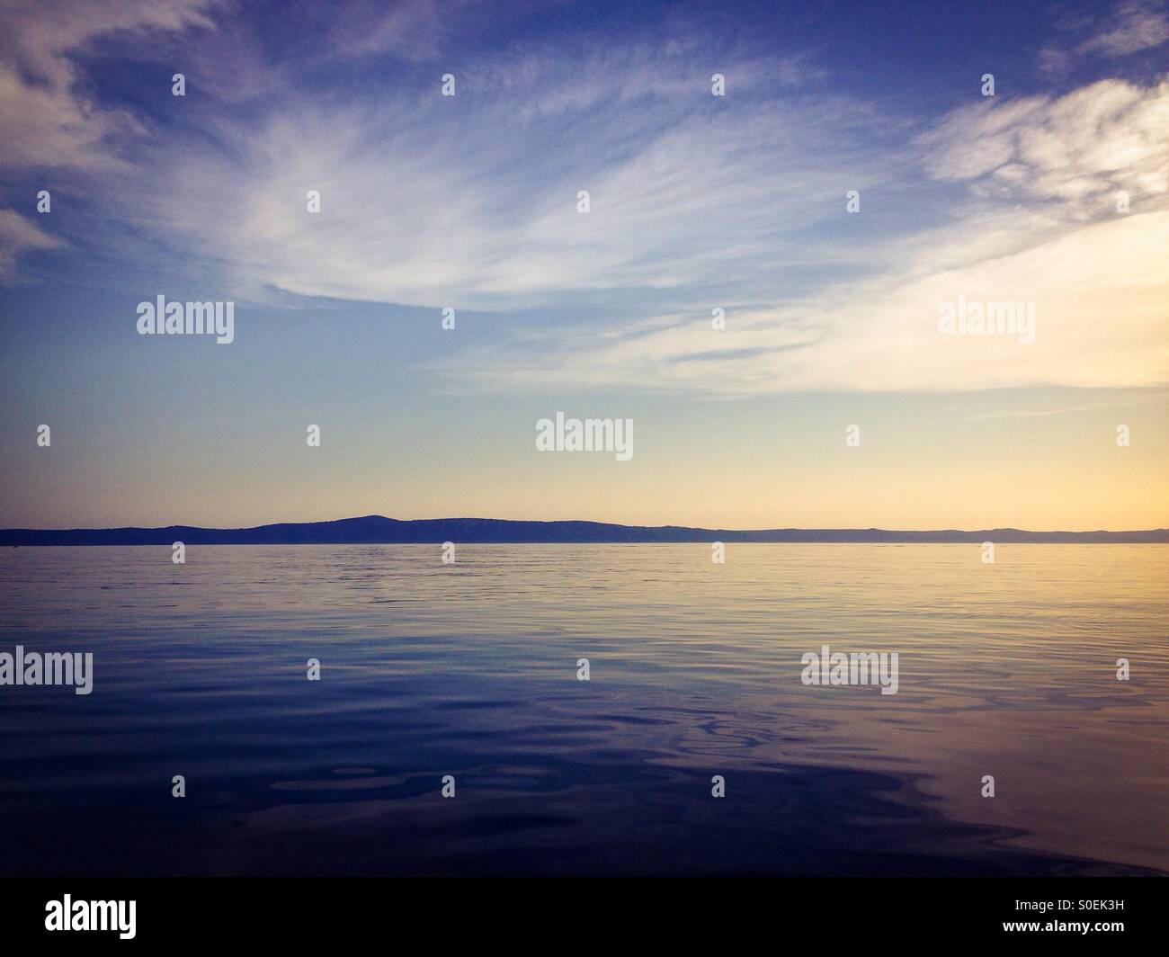 Landscape scene of calm blue Adriatic sea with island in background Stock Photo