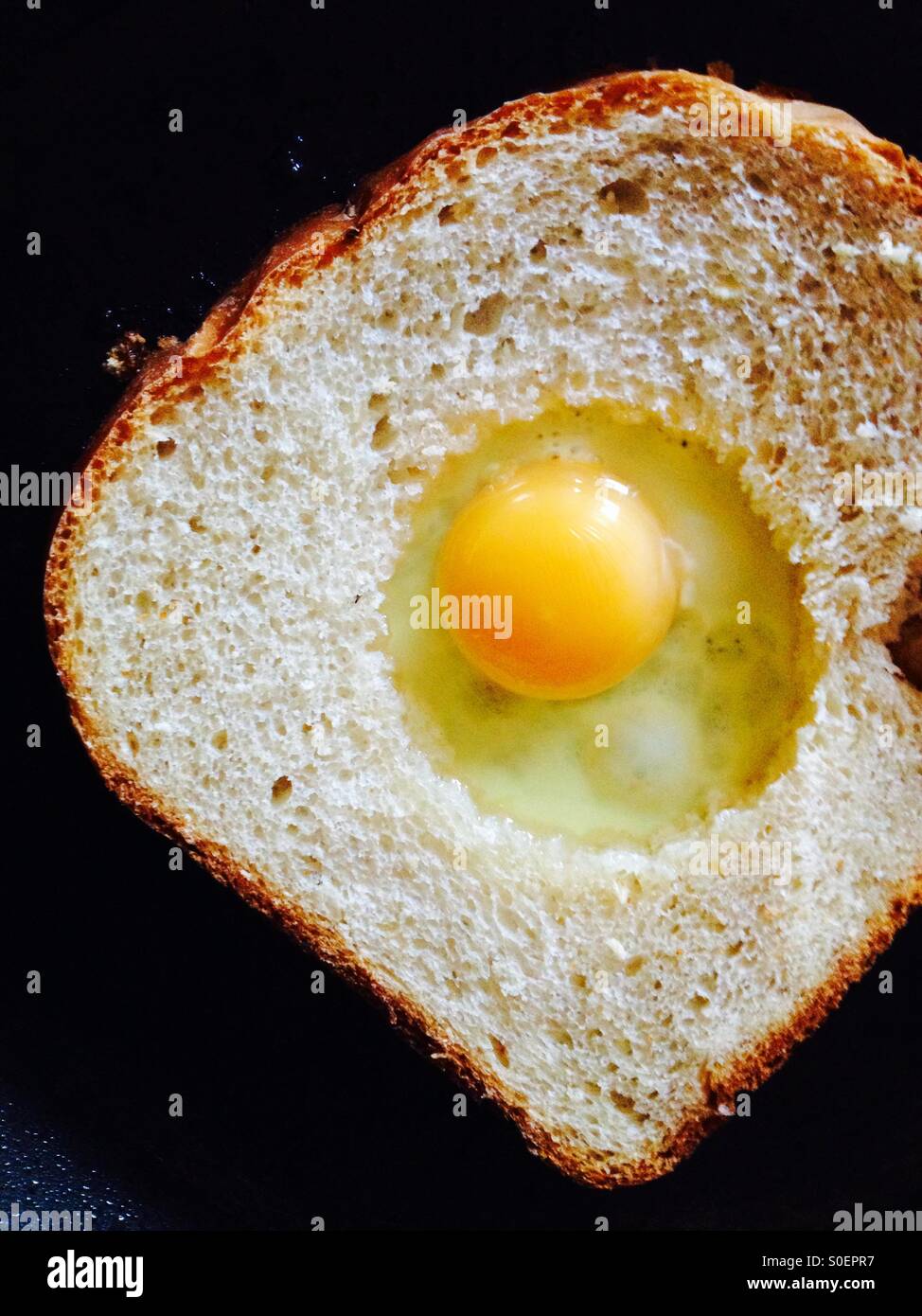 Egg surprise (fried egg in fried bread) in frying pan Stock Photo Alamy