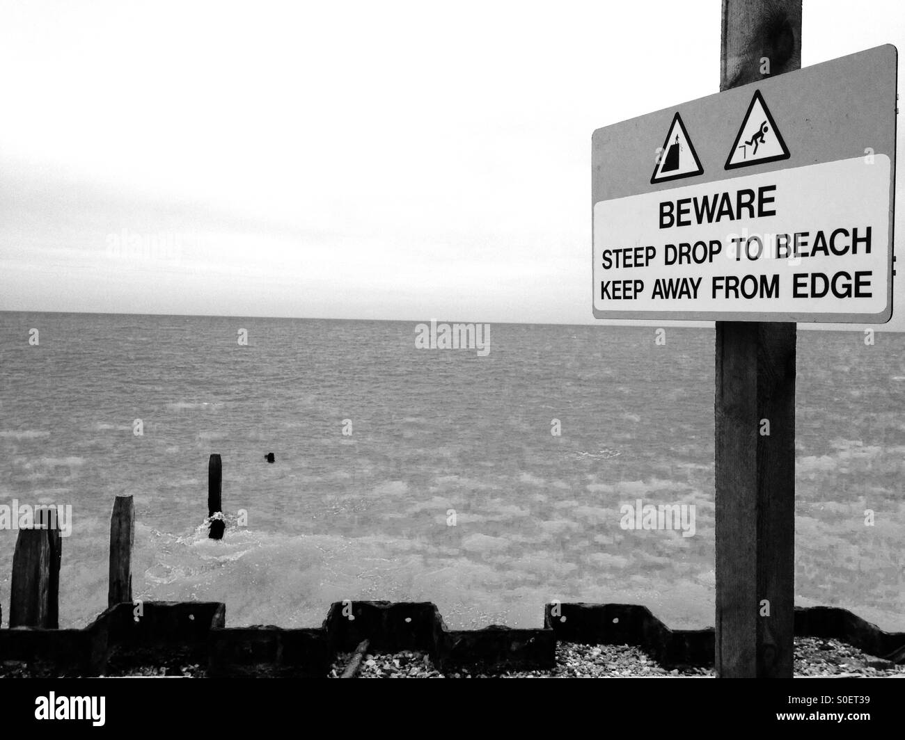 Beware steep drop to beach keep away from edge sign, Bawdsey Ferry, Suffolk, UK. Stock Photo