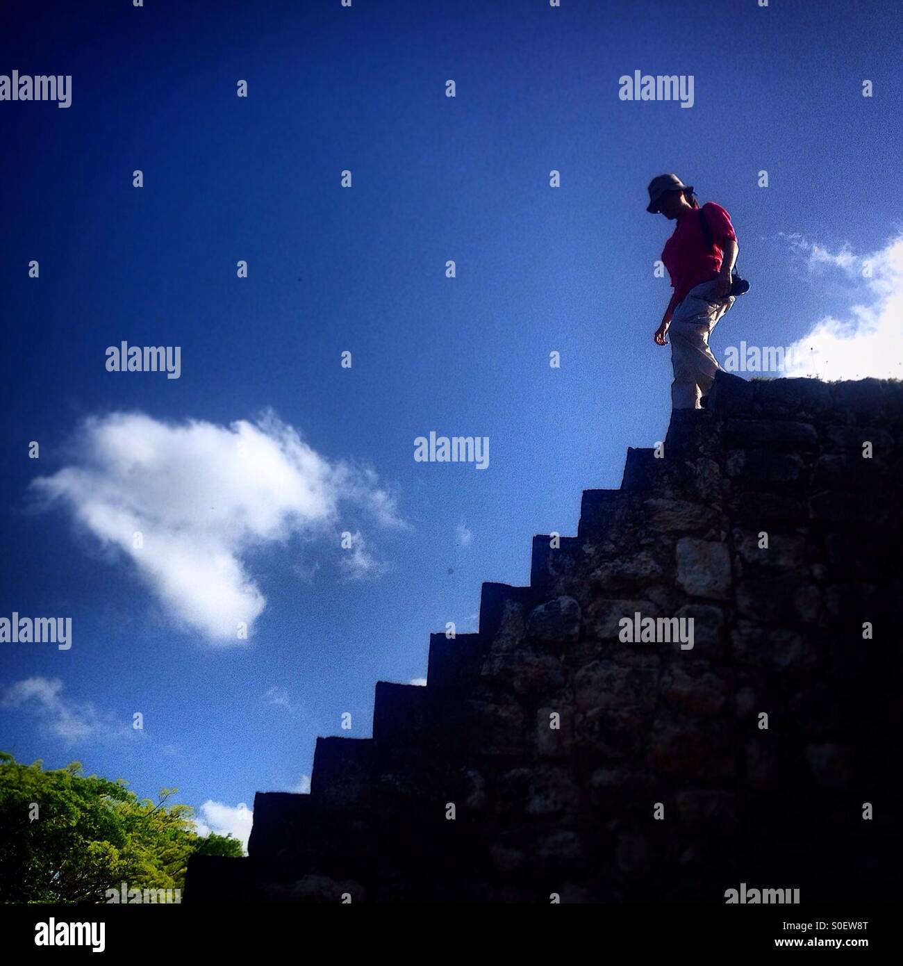 A woman walks down stairs in the ancient Mayan city of Kabah, in the Ruta Puuc, Yucatan, Mexico Stock Photo