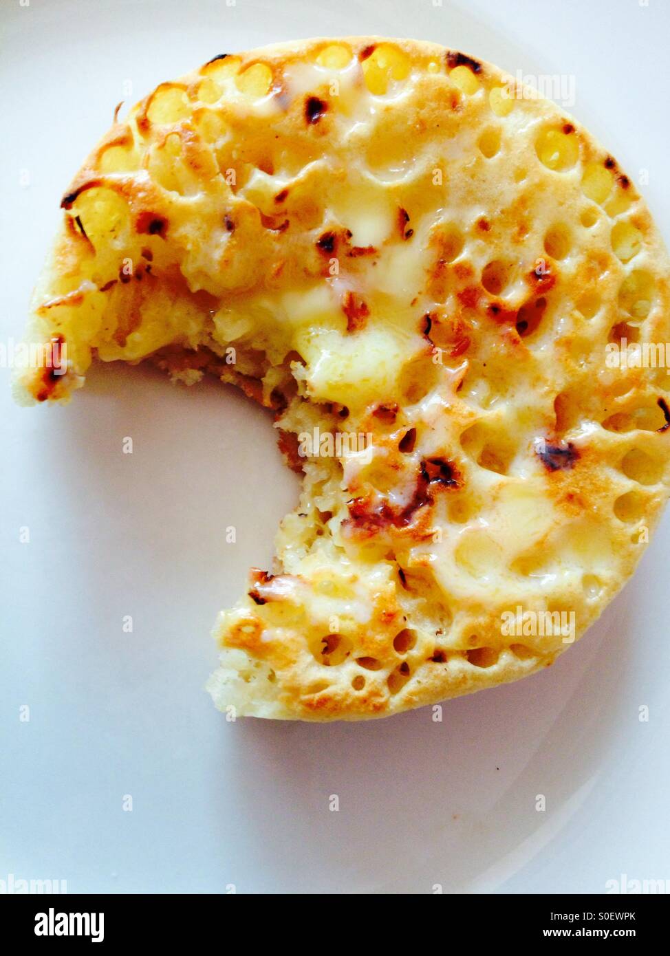 Buttered crumpet with bite taken out - Smartphone Captured Stock Image