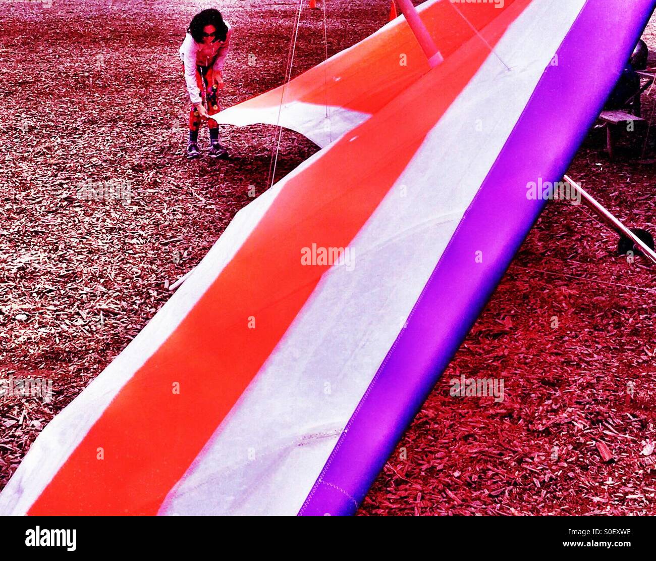 Young woman hang glider preflight rig check in Northern California - Smartphone Captured Stock Image