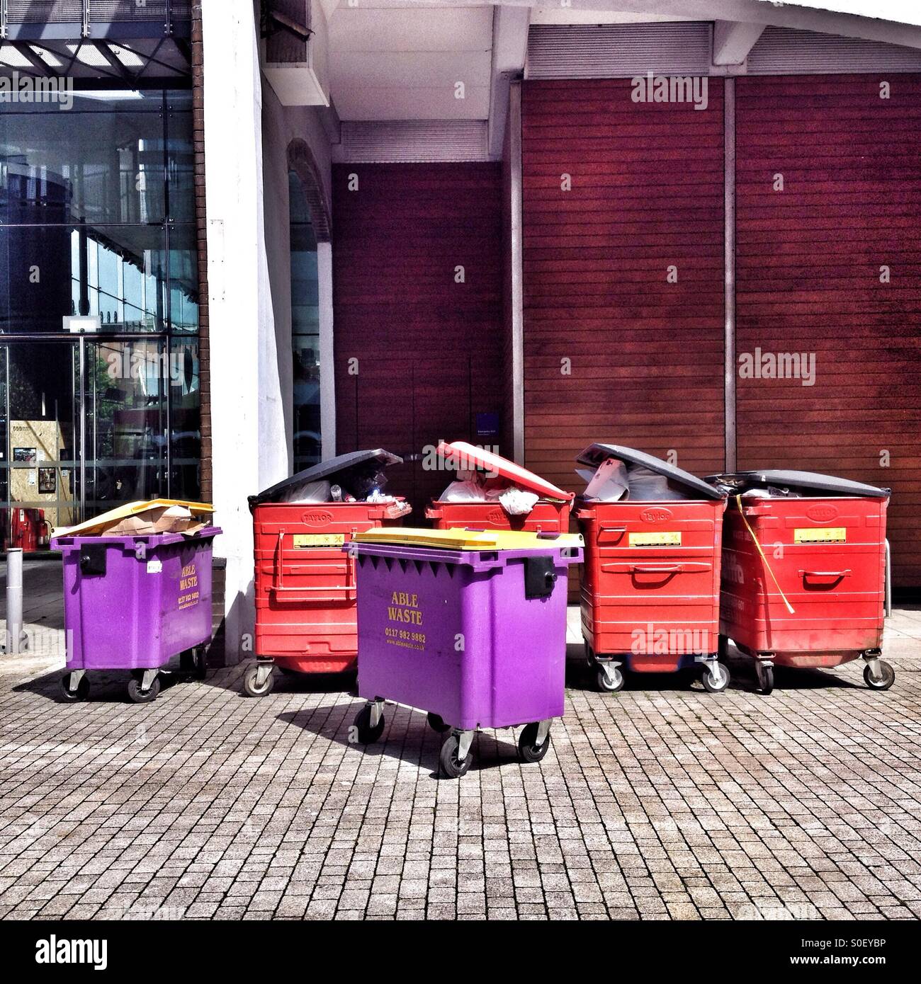 Brightly-coloured wheelybins standing by the roadside Stock Photo