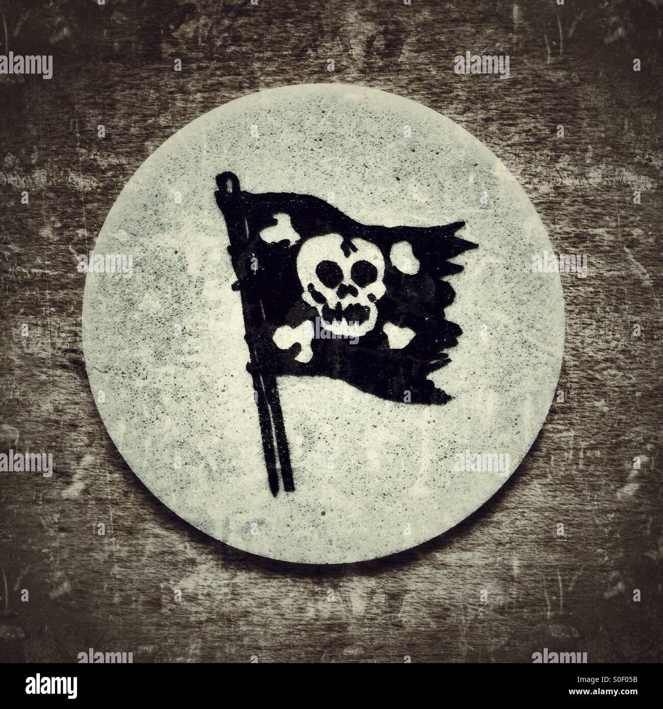 A tongue tattoo of a pirate flag with crossbones and skull printed on edible paper for children - Smartphone Captured Stock Image
