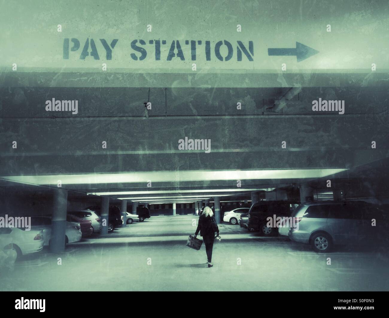 Blonde woman shopper returns to her car in an underground parking garage at a shopping mall - Smartphone Captured Stock Image