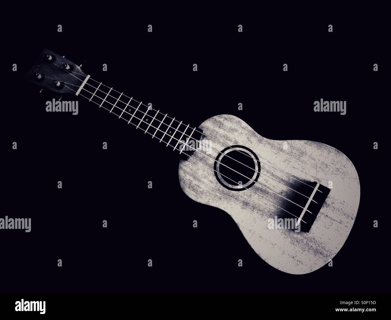 A Ukulele before a Black background - Smartphone Captured Stock Image