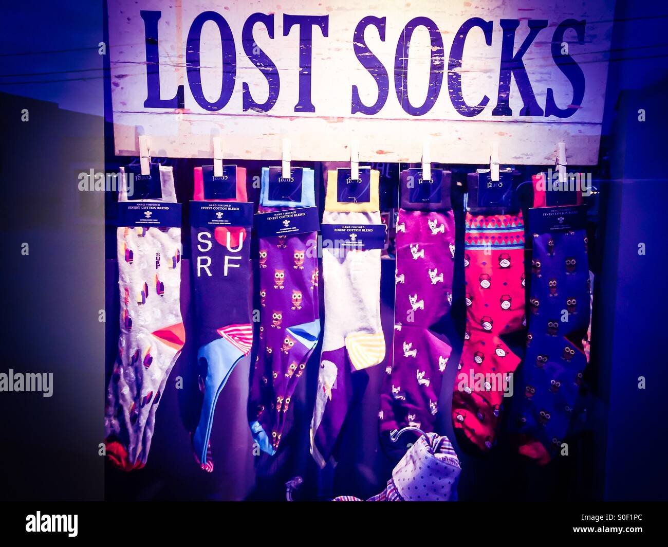 Lost. One of a kind socks displayed on a bar in a store window. Common gift suggestion for Everyman, popular around Father’s Day, in a Clothing Shop, Ontario, Canada. - Smartphone Captured Stock Image
