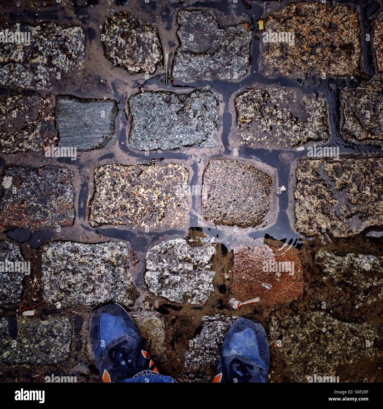 Feet selfie on Wet Cobblestones in the Rain Stock Photo