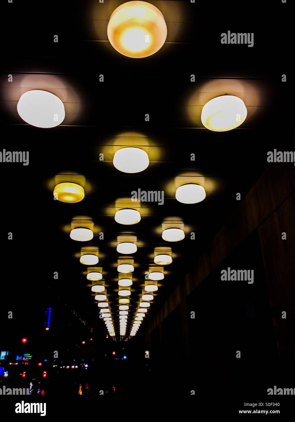 Rows of lights on the ceiling of a theatre lobby, Ontario, Canada. Parallel rows which seem to morph into a triangular space. Concepts: decor, decoration, illumination, perspective. - Smartphone Captured Stock Image