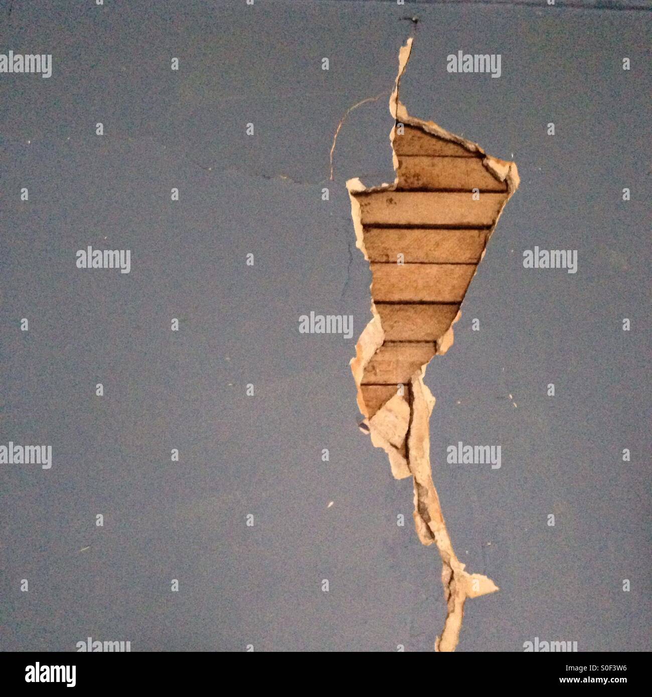 Cracked plaster revealing underlying structure in Detroit house - Smartphone Captured Stock Image