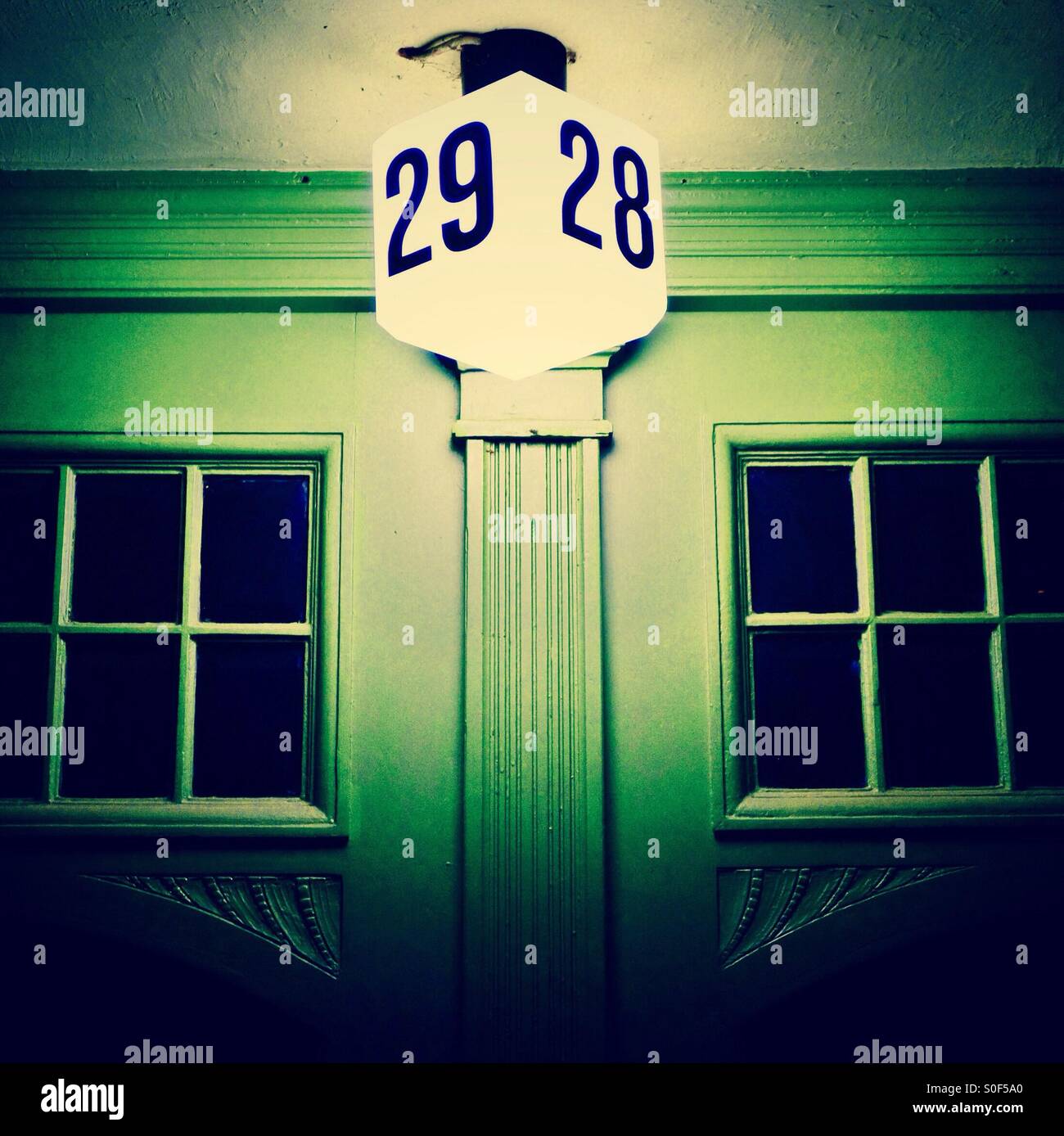 Green door with lit numbers -28 & 29 - Smartphone Captured Stock Image