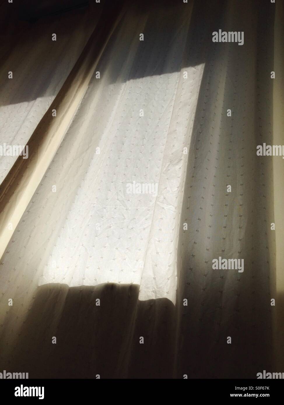 Sun shining through white sheer curtains Stock Photo